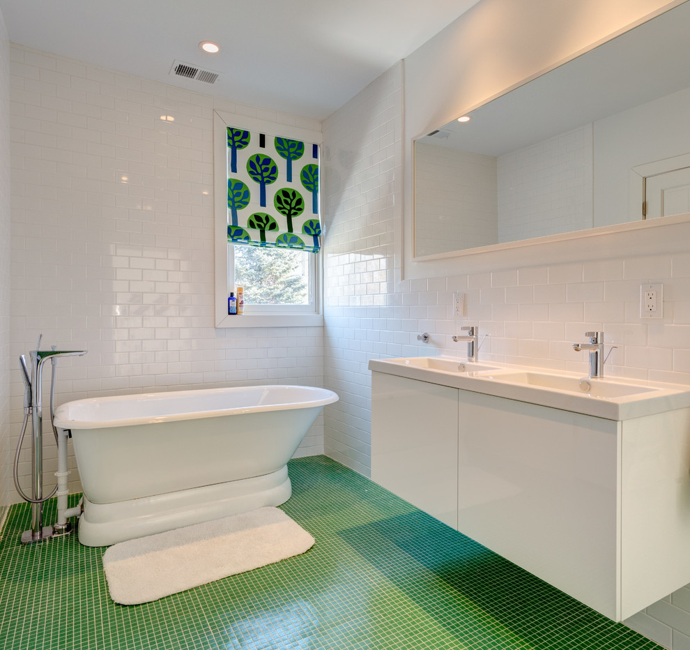 Example of a large minimalist kids' white tile and subway tile green floor and ceramic tile bathroom design in New York with flat-panel cabinets, a two-piece toilet, white walls, an integrated sink, solid surface countertops, white cabinets and white countertops