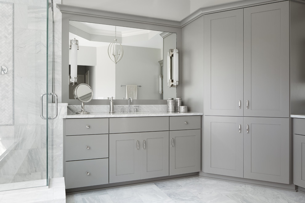 Réalisation d'une salle de bain principale design de taille moyenne avec un lavabo encastré, des portes de placard grises et un carrelage gris.