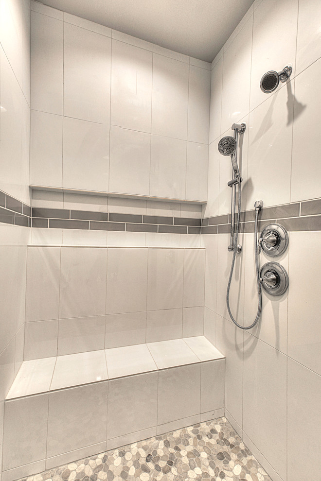 Cette image montre une grande salle de bain traditionnelle avec un placard à porte shaker, des portes de placard blanches, WC séparés, un carrelage gris, un carrelage métro, un mur gris, un sol en carrelage de porcelaine, un plan de toilette en surface solide et un sol gris.