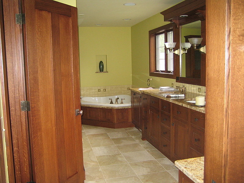 This is an example of a medium sized world-inspired ensuite bathroom in Chicago with a submerged sink, beaded cabinets, dark wood cabinets and a corner bath.