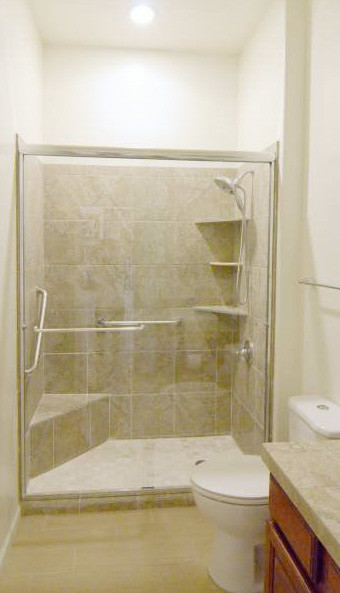 Bild på ett mellanstort funkis badrum med dusch, med ett undermonterad handfat, luckor med upphöjd panel, skåp i mellenmörkt trä, granitbänkskiva, en dusch i en alkov, en toalettstol med hel cisternkåpa, beige kakel, porslinskakel, vita väggar och klinkergolv i porslin