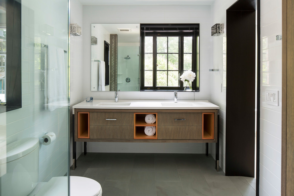 На фото: главная ванная комната в современном стиле с белой плиткой, белыми стенами, столешницей из искусственного кварца, серым полом, белой столешницей, темными деревянными фасадами, врезной раковиной и плоскими фасадами с