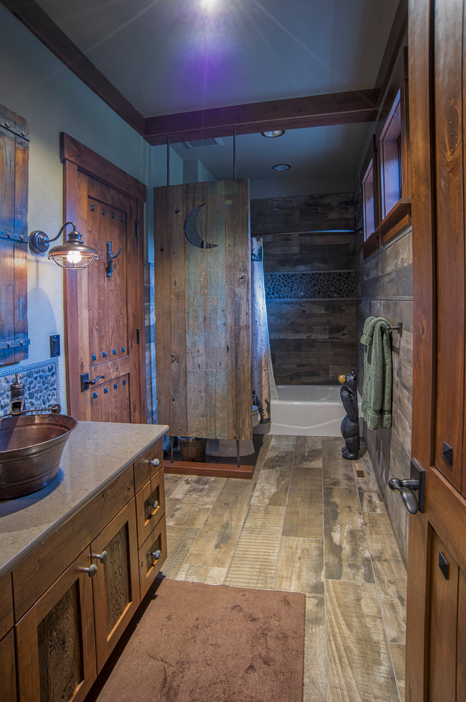 Ejemplo de cuarto de baño rústico con armarios estilo shaker, puertas de armario de madera en tonos medios, combinación de ducha y bañera y lavabo sobreencimera