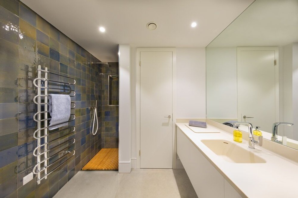 Mid-sized trendy 3/4 white tile and ceramic tile cement tile floor and gray floor bathroom photo in Oxfordshire with a one-piece toilet, gray walls, flat-panel cabinets, gray cabinets, a drop-in sink and concrete countertops