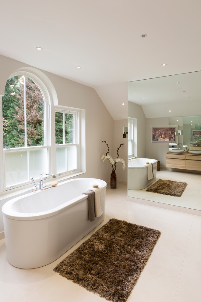 Exempel på ett klassiskt badrum, med ett fristående badkar och grå väggar