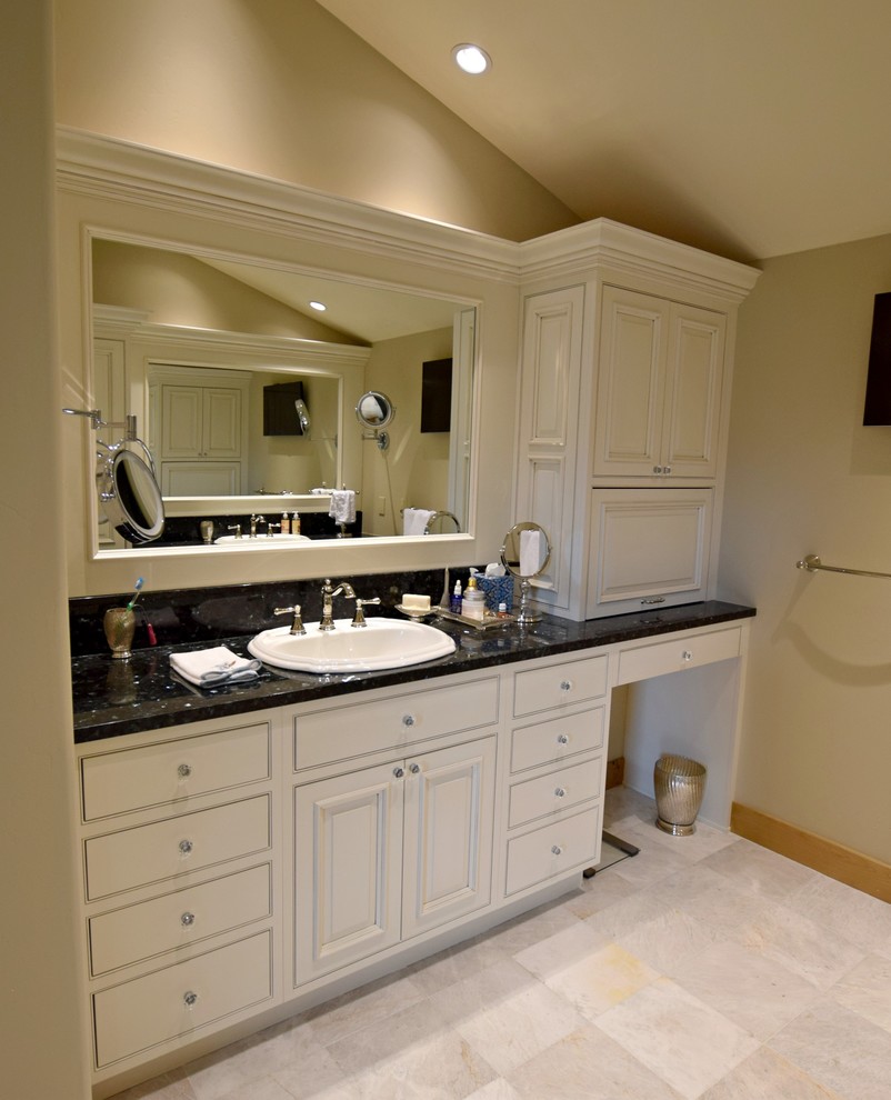 Cette image montre une salle de bain principale traditionnelle avec un placard à porte affleurante, des portes de placard blanches, un mur beige et un lavabo posé.