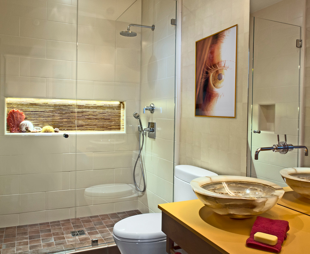Idée de décoration pour une salle de bain design en bois clair avec un placard à porte shaker, WC à poser, un carrelage beige, un mur beige et une vasque.