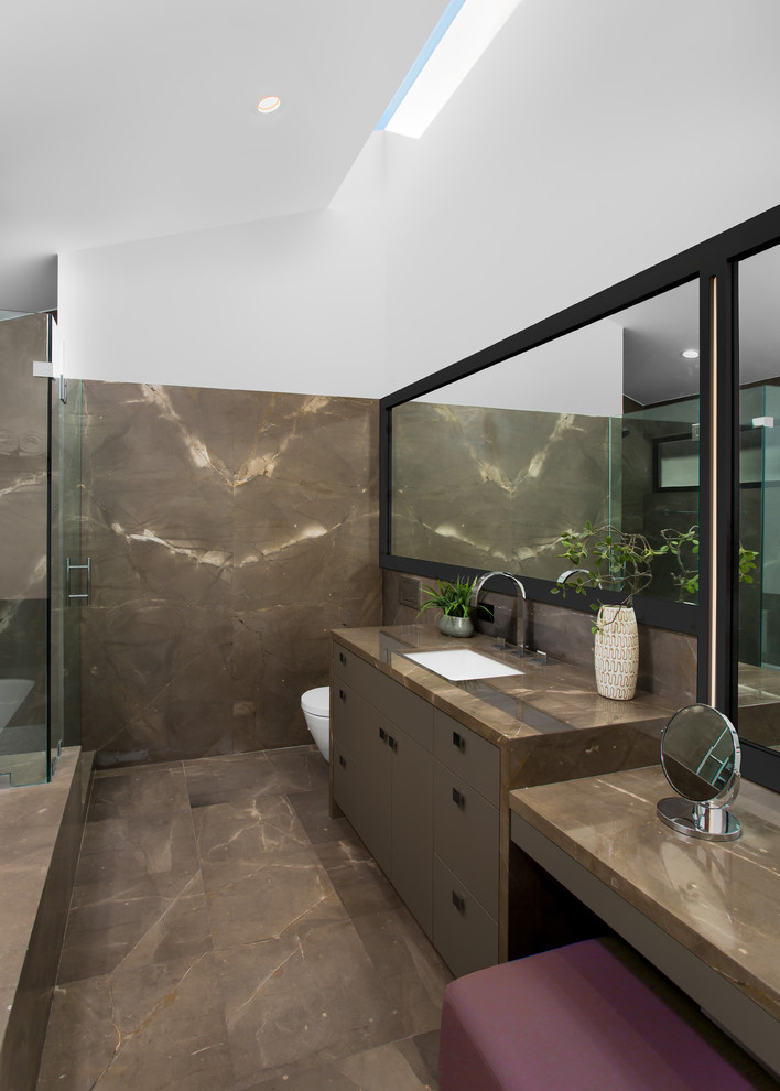 Пример оригинального дизайна: главная ванная комната среднего размера в современном стиле с плоскими фасадами, коричневыми фасадами, полновстраиваемой ванной, угловым душем, инсталляцией, коричневой плиткой, плиткой из листового камня, белыми стенами, мраморным полом, врезной раковиной, мраморной столешницей, коричневым полом и душем с распашными дверями