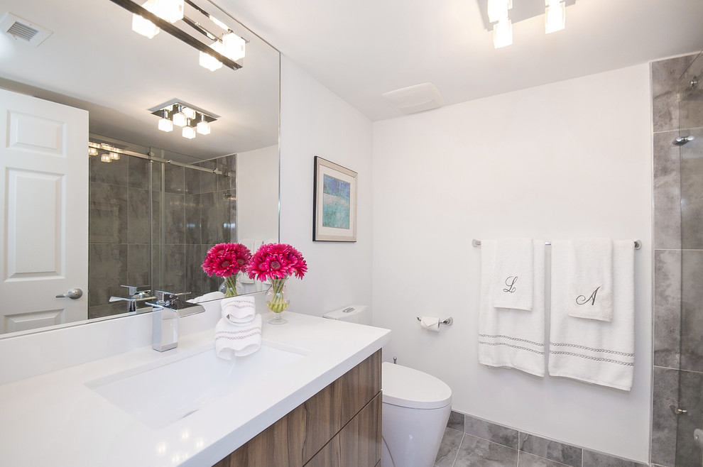 Small minimalist master gray tile and porcelain tile porcelain tile and gray floor doorless shower photo in Miami with an undermount sink, flat-panel cabinets, medium tone wood cabinets, quartz countertops, a two-piece toilet, white walls and a hinged shower door