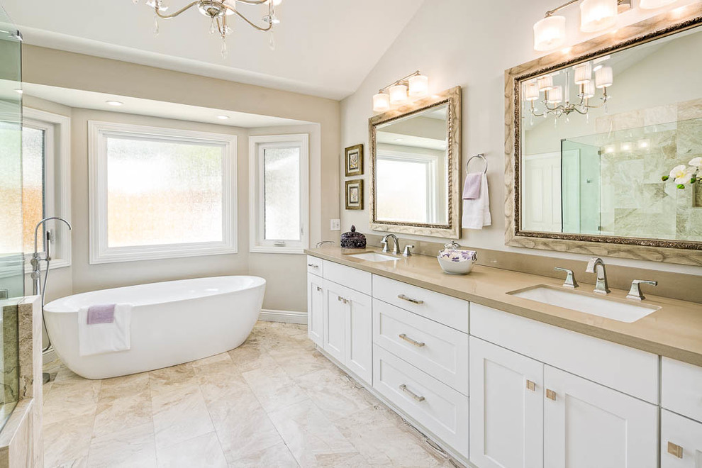 Example of a huge transitional master marble floor and beige floor bathroom design in Los Angeles with shaker cabinets, white cabinets, a one-piece toilet, beige walls, a drop-in sink, quartz countertops and a hinged shower door