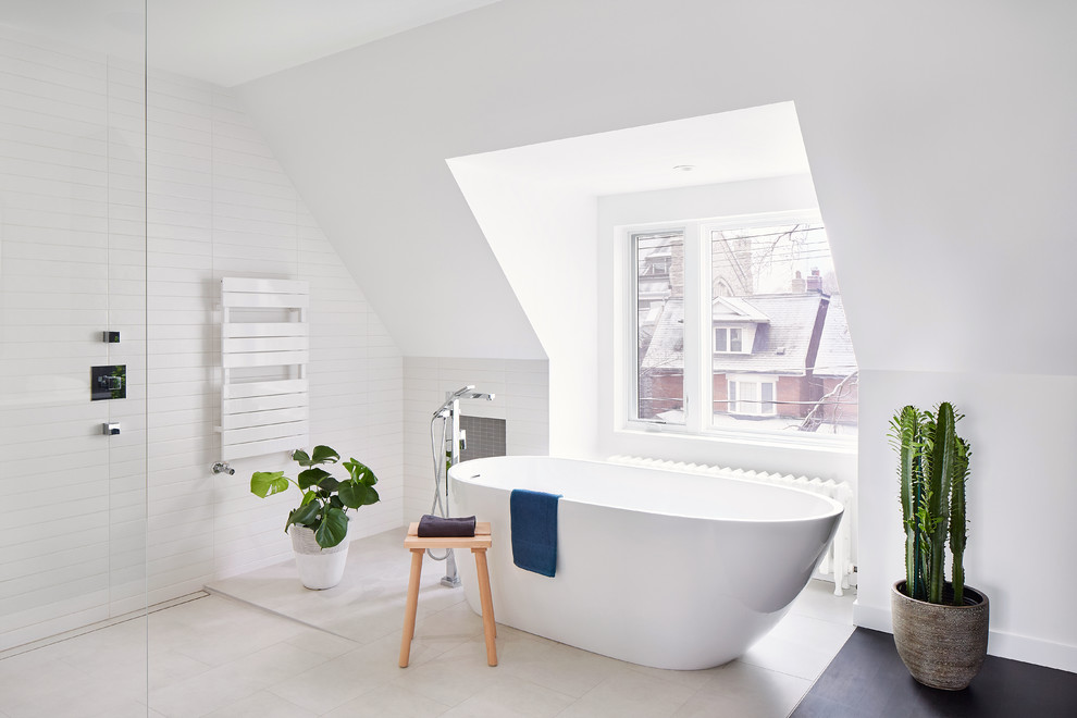 This is an example of a contemporary bathroom in Toronto with a freestanding bath, a built-in shower, white tiles, ceramic tiles, white walls, an open shower and beige floors.