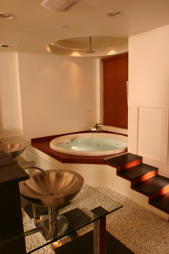 Immagine di una grande stanza da bagno padronale minimalista con pareti bianche, lavabo a bacinella, top in vetro e vasca da incasso