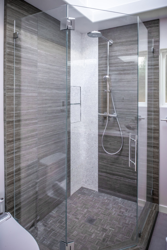 Réalisation d'une salle de bain principale design en bois foncé de taille moyenne avec une douche d'angle, WC à poser, un mur gris, un sol gris, une cabine de douche à porte battante, un placard à porte plane, un lavabo encastré et un plan de toilette en surface solide.