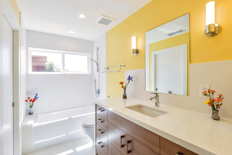 Example of a small trendy white tile and ceramic tile ceramic tile bathroom design in Los Angeles with flat-panel cabinets, dark wood cabinets, a one-piece toilet, yellow walls, an undermount sink and quartz countertops