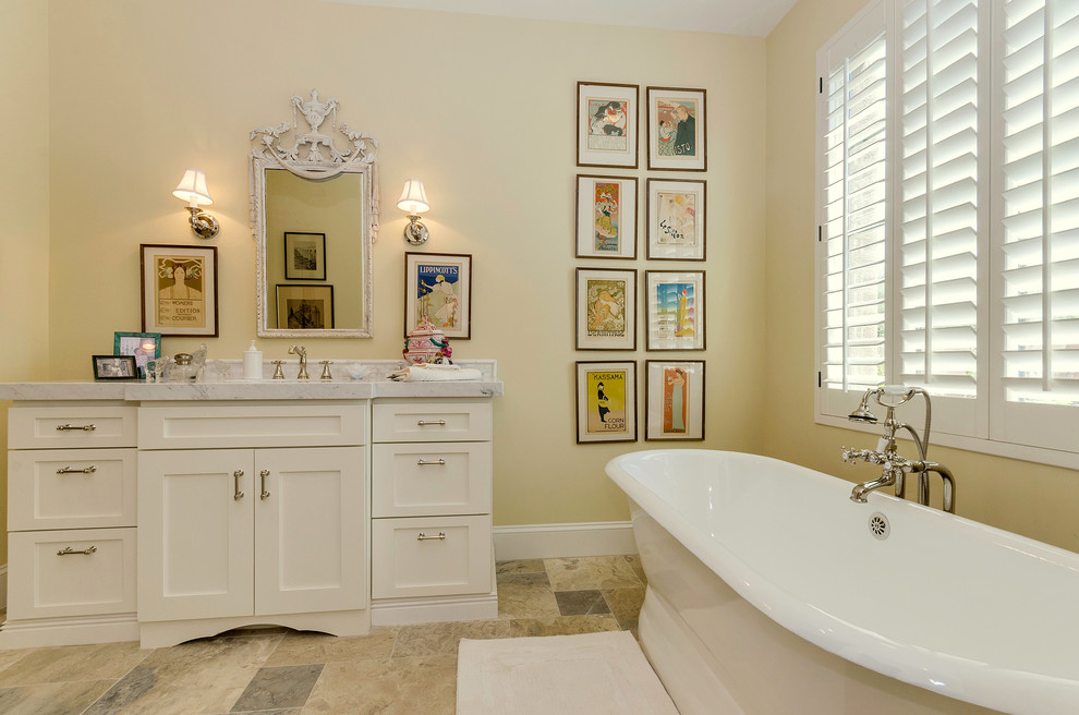 Foto på ett medelhavsstil badrum, med skåp i shakerstil, vita skåp, ett fristående badkar och beige väggar