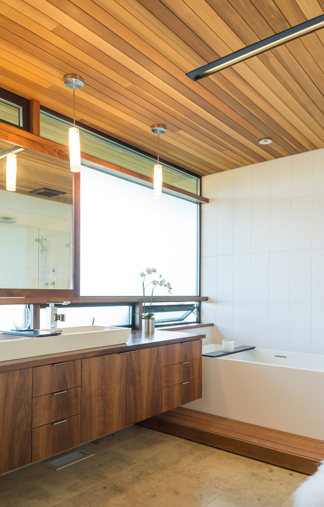 Design ideas for a contemporary bathroom in Seattle with a vessel sink, flat-panel cabinets, wooden worktops, an alcove bath, beige tiles, dark wood cabinets and brown worktops.