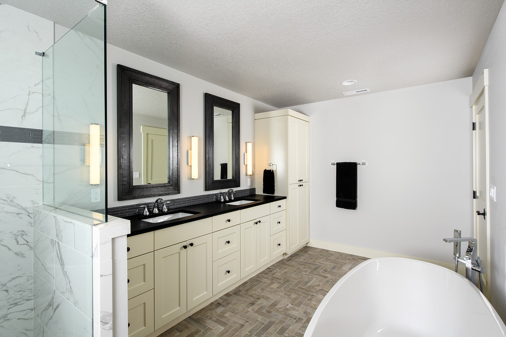 Idéer för att renovera ett mellanstort funkis en-suite badrum, med skåp i shakerstil, vita skåp, ett fristående badkar, en hörndusch, en toalettstol med separat cisternkåpa, vit kakel, marmorkakel, beige väggar, klinkergolv i porslin, ett undermonterad handfat, granitbänkskiva, beiget golv och dusch med gångjärnsdörr
