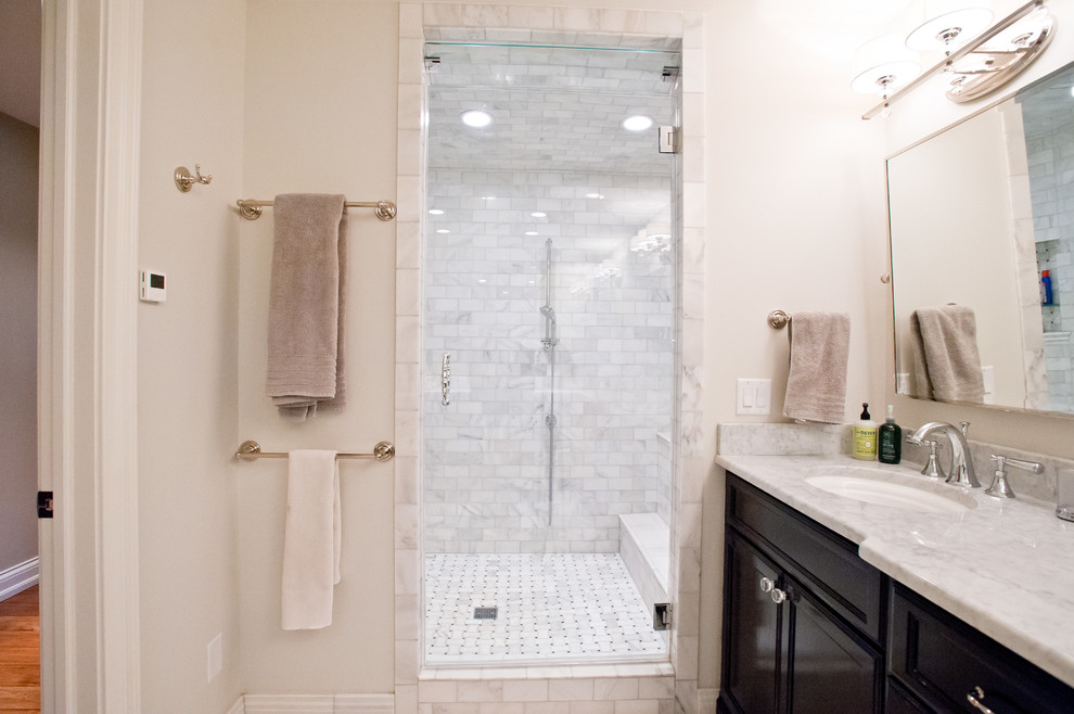 Inspiration for a mid-sized timeless white tile and porcelain tile marble floor double shower remodel in Milwaukee with an undermount sink, recessed-panel cabinets, black cabinets, marble countertops, a two-piece toilet and white walls