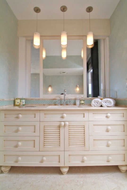 Réalisation d'une salle de bain marine avec un lavabo encastré, un placard à porte persienne, des portes de placard beiges, un plan de toilette en marbre, un carrelage beige et un carrelage de pierre.