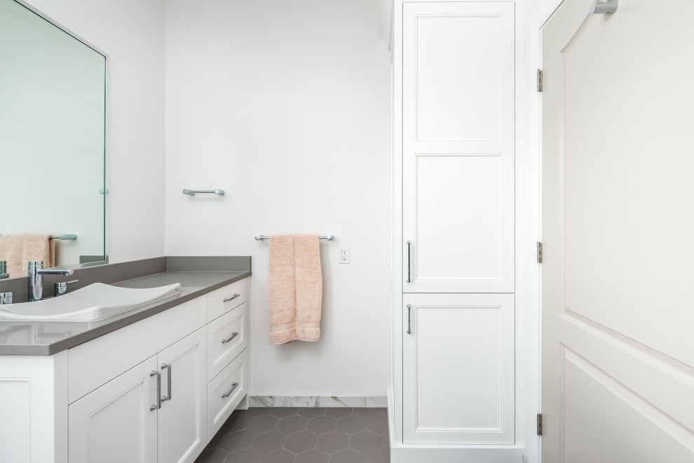 Immagine di una stanza da bagno tradizionale con ante a filo, ante bianche, piastrelle bianche, piastrelle di marmo, pareti bianche, lavabo a bacinella, pavimento grigio e top grigio