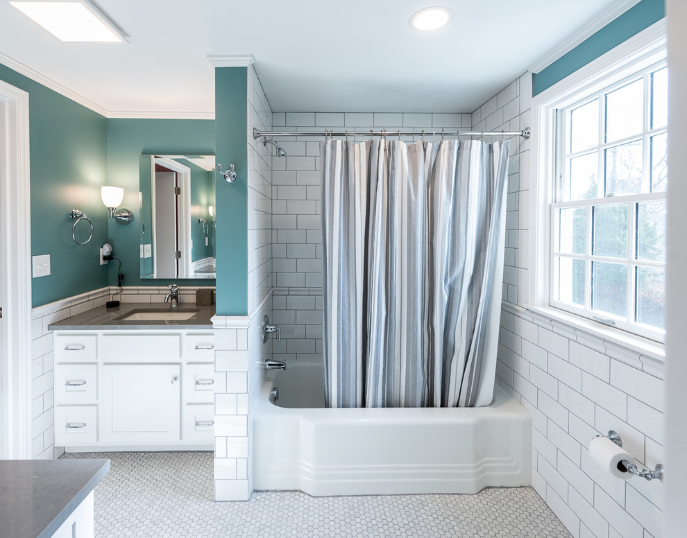 Cette photo montre une salle de bain chic de taille moyenne pour enfant avec un placard à porte shaker, des portes de placard blanches, une baignoire en alcôve, un combiné douche/baignoire, WC séparés, un carrelage blanc, un carrelage métro, un mur bleu, un sol en marbre, un lavabo encastré, un plan de toilette en quartz modifié, un sol gris, une cabine de douche avec un rideau et un plan de toilette gris.