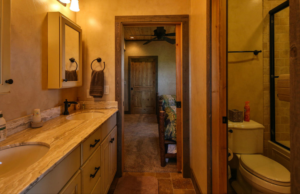 Exempel på ett mellanstort rustikt badrum för barn, med släta luckor, vita skåp, en dusch/badkar-kombination, en toalettstol med hel cisternkåpa, beige väggar, klinkergolv i keramik, ett undermonterad handfat och granitbänkskiva