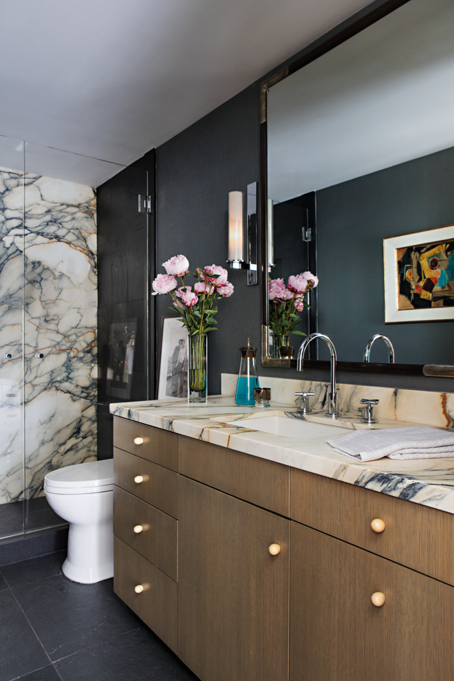 Foto di una stanza da bagno contemporanea con ante lisce, ante in legno scuro, lavabo sottopiano, pavimento nero e top beige