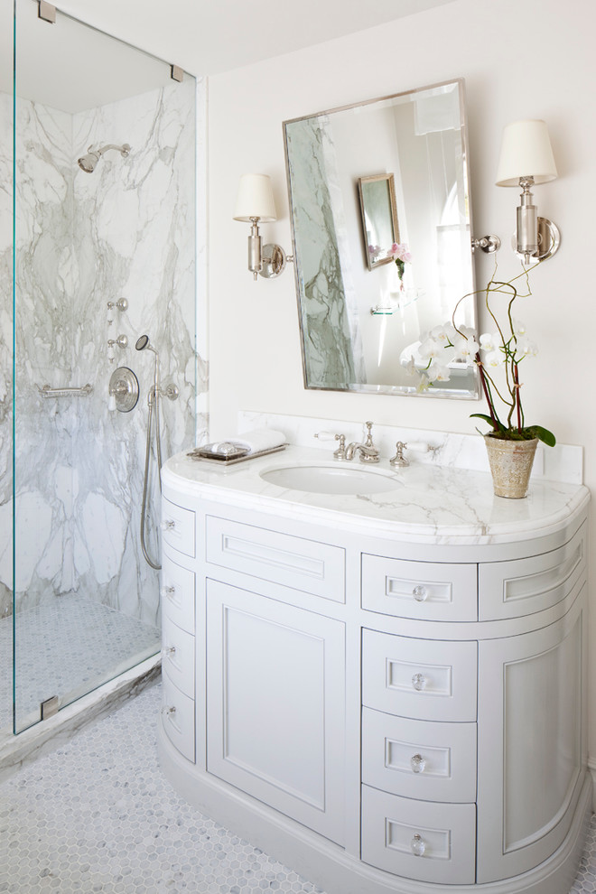 Стильный дизайн: главная ванная комната среднего размера в классическом стиле с белой плиткой, ванной на ножках, угловым душем, бежевыми стенами, полом из мозаичной плитки, фасадами с утопленной филенкой, белыми фасадами, плиткой из листового камня, врезной раковиной и мраморной столешницей - последний тренд