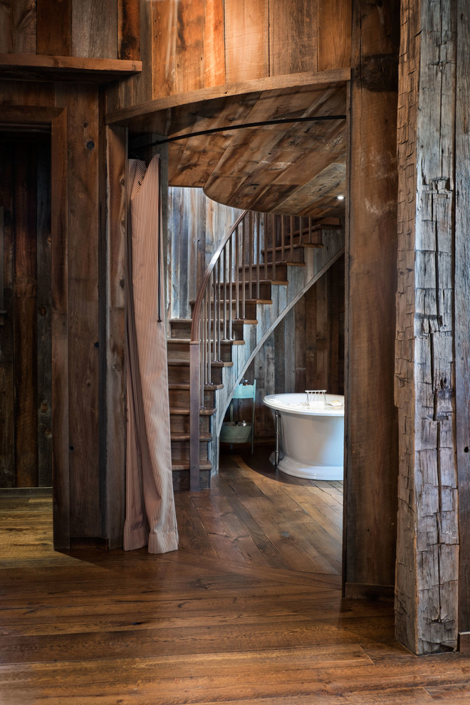 На фото: главная ванная комната в стиле рустика с отдельно стоящей ванной, коричневыми стенами и темным паркетным полом
