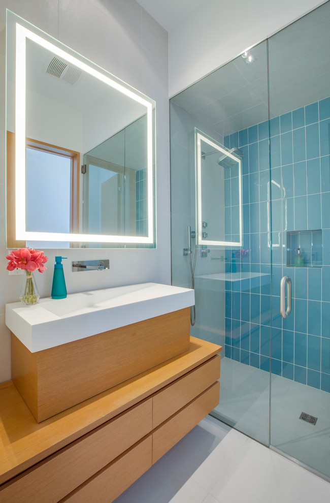 Imagen de cuarto de baño contemporáneo con armarios con paneles lisos, puertas de armario de madera oscura, ducha empotrada, paredes azules, lavabo encastrado y suelo gris