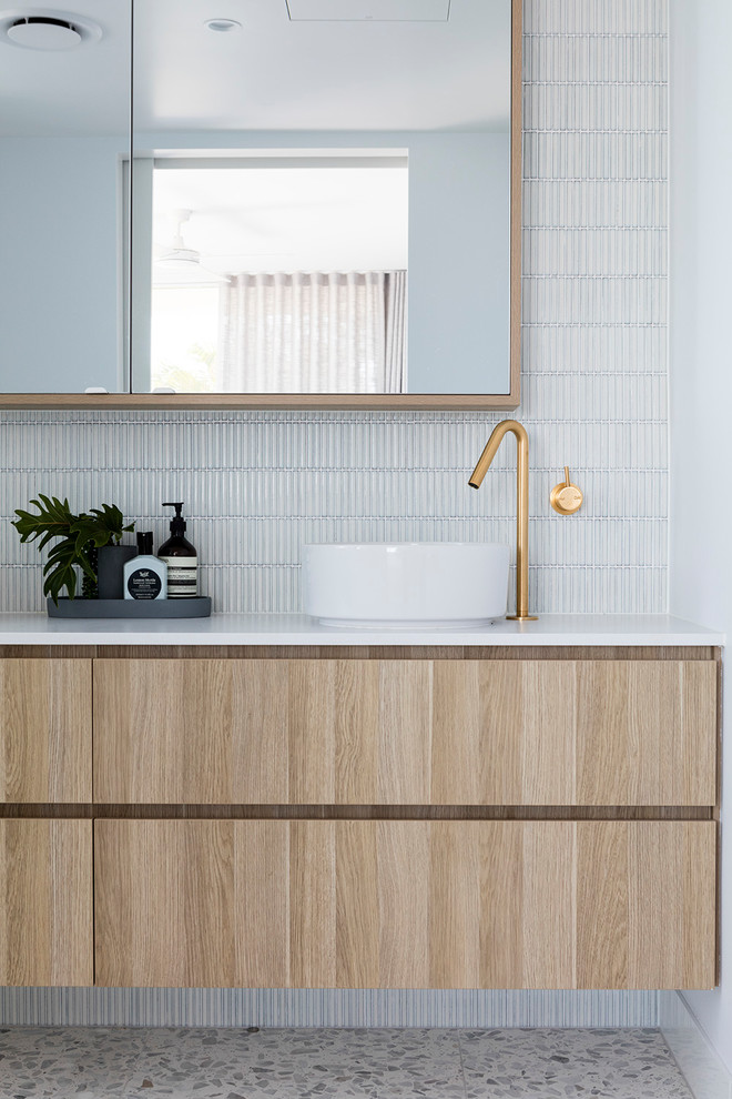 Idee per una stanza da bagno minimal di medie dimensioni con ante lisce, ante in legno chiaro, piastrelle bianche, piastrelle a mosaico, pareti grigie, lavabo a bacinella, pavimento grigio e top bianco