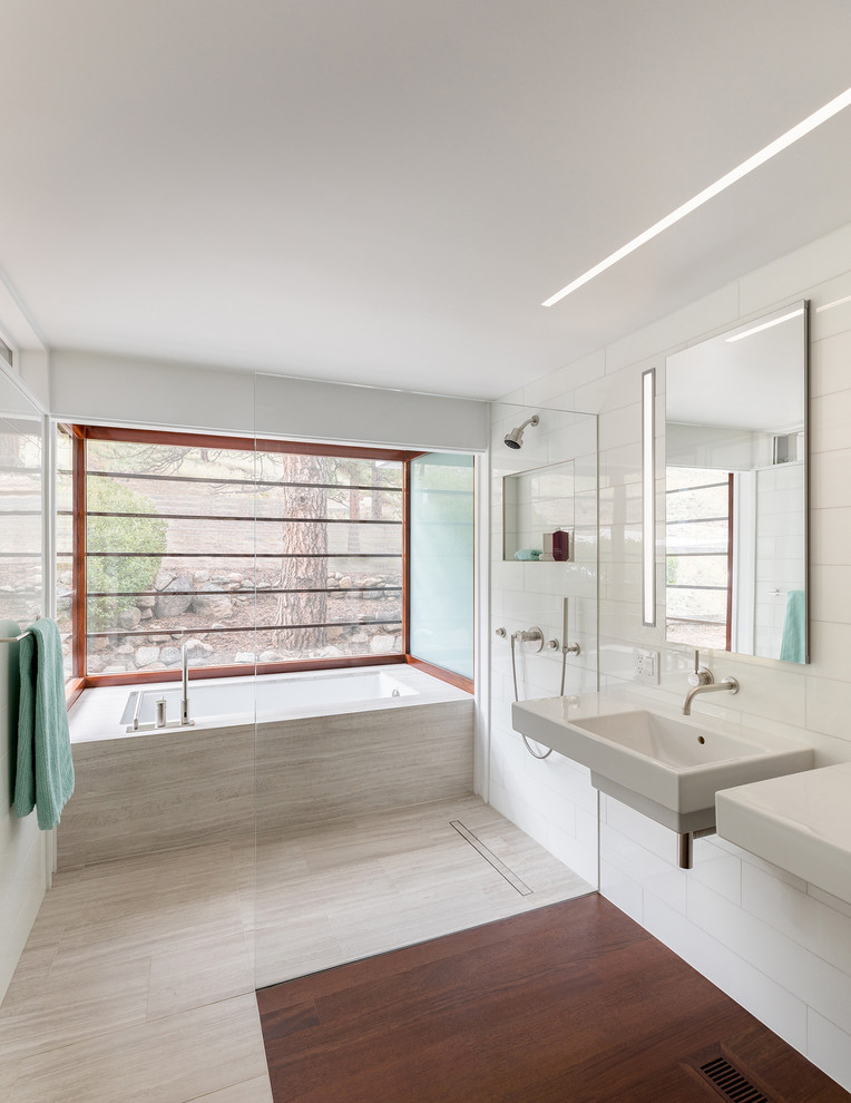 ニューヨークにあるコンテンポラリースタイルのおしゃれなマスターバスルーム (アルコーブ型浴槽、オープン型シャワー、白いタイル、白い壁、壁付け型シンク、ベージュの床、オープンシャワー) の写真