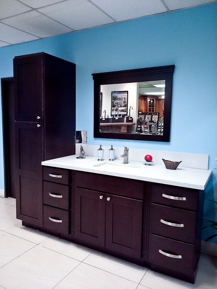 Aménagement d'une petite salle de bain sud-ouest américain en bois foncé pour enfant avec un lavabo encastré, un placard à porte shaker, un plan de toilette en quartz modifié, un mur bleu et un sol en carrelage de porcelaine.