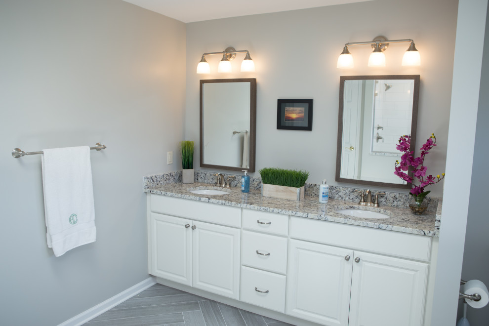 Example of a large transitional master white tile and ceramic tile porcelain tile, gray floor and double-sink bathroom design in Chicago with raised-panel cabinets, white cabinets, a two-piece toilet, gray walls, an undermount sink, granite countertops, a hinged shower door, gray countertops and a built-in vanity