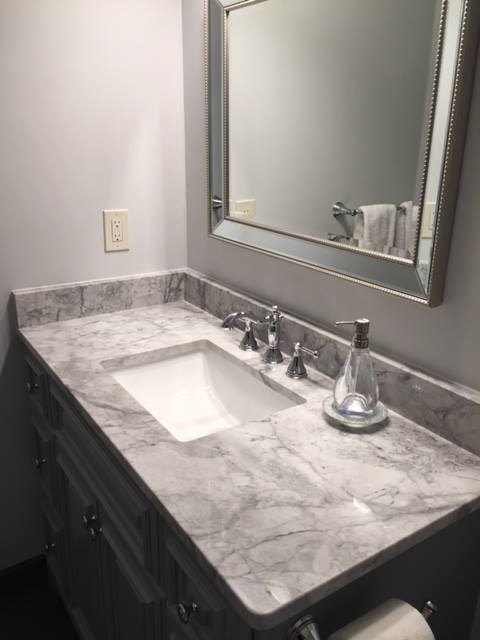 Foto di una stanza da bagno design con top in granito, ante verdi e lavabo sottopiano