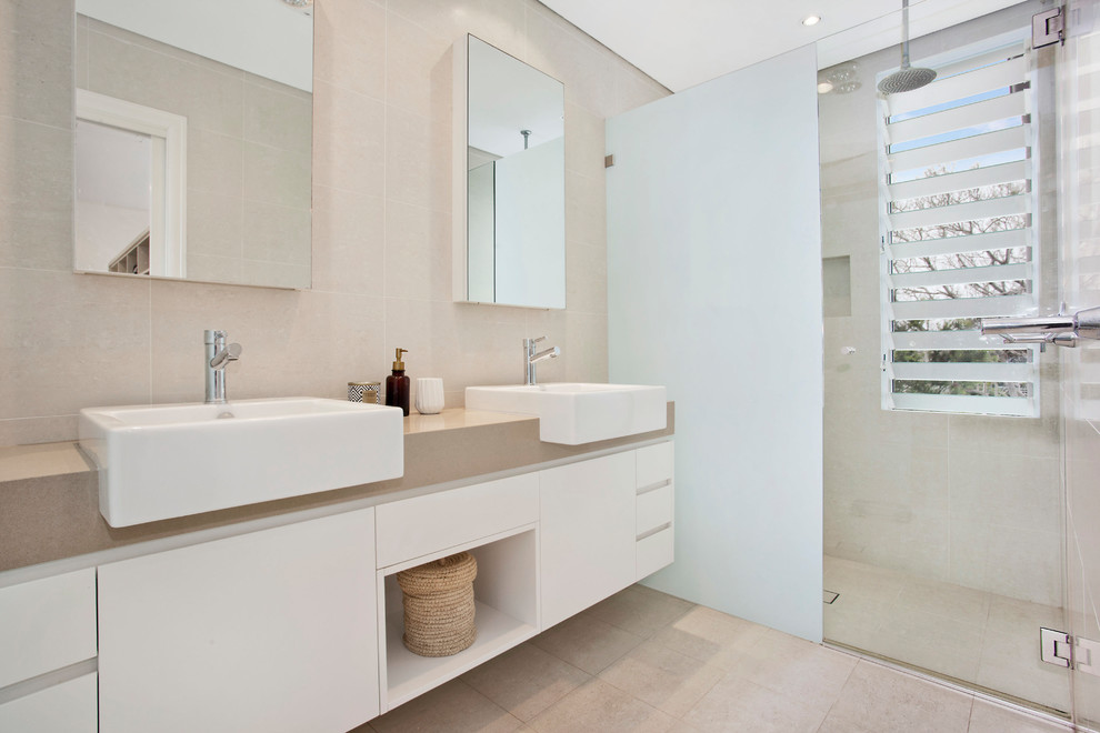 Inspiration för moderna beige en-suite badrum, med dusch med gångjärnsdörr, släta luckor, vita skåp, en dusch i en alkov, beige kakel, travertinkakel, beige väggar, klinkergolv i porslin, ett nedsänkt handfat, bänkskiva i akrylsten och beiget golv