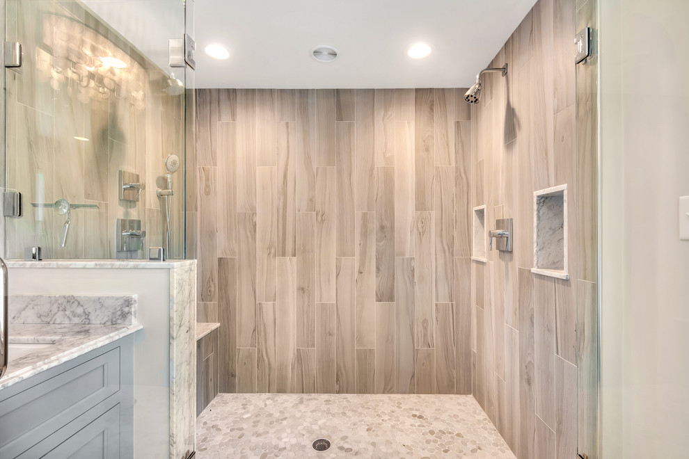 Inspiration for a large traditional ensuite bathroom in Boston with grey cabinets, a double shower, a one-piece toilet, grey tiles, ceramic tiles, grey walls, ceramic flooring, a submerged sink, marble worktops, grey floors, a hinged door, recessed-panel cabinets and white worktops.