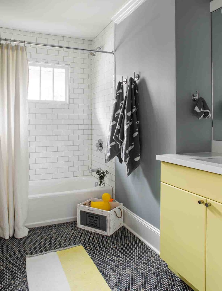 Идея дизайна: детская ванная комната среднего размера в стиле неоклассика (современная классика) с желтыми фасадами, ванной в нише, белой плиткой, керамической плиткой, серыми стенами, полом из мозаичной плитки, врезной раковиной, столешницей из искусственного кварца и серым полом