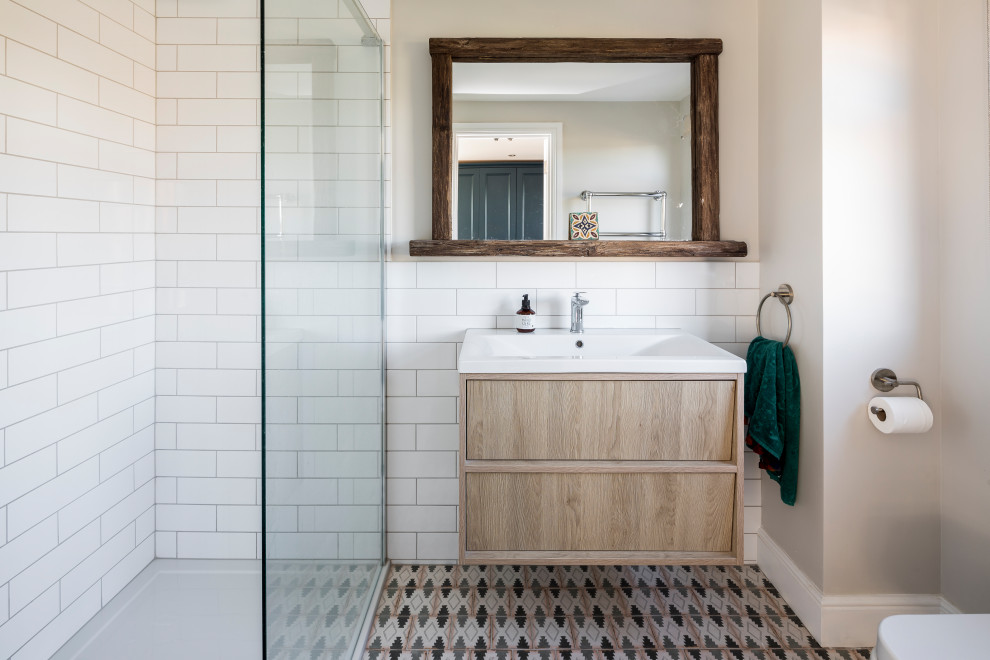 Medium sized contemporary shower room bathroom in London with flat-panel cabinets, light wood cabinets, white tiles, metro tiles, grey walls, an integrated sink, multi-coloured floors, white worktops, a single sink and a floating vanity unit.