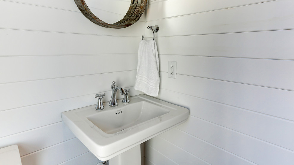 Foto di una piccola stanza da bagno stile marinaro con pareti bianche, parquet chiaro e lavabo a colonna