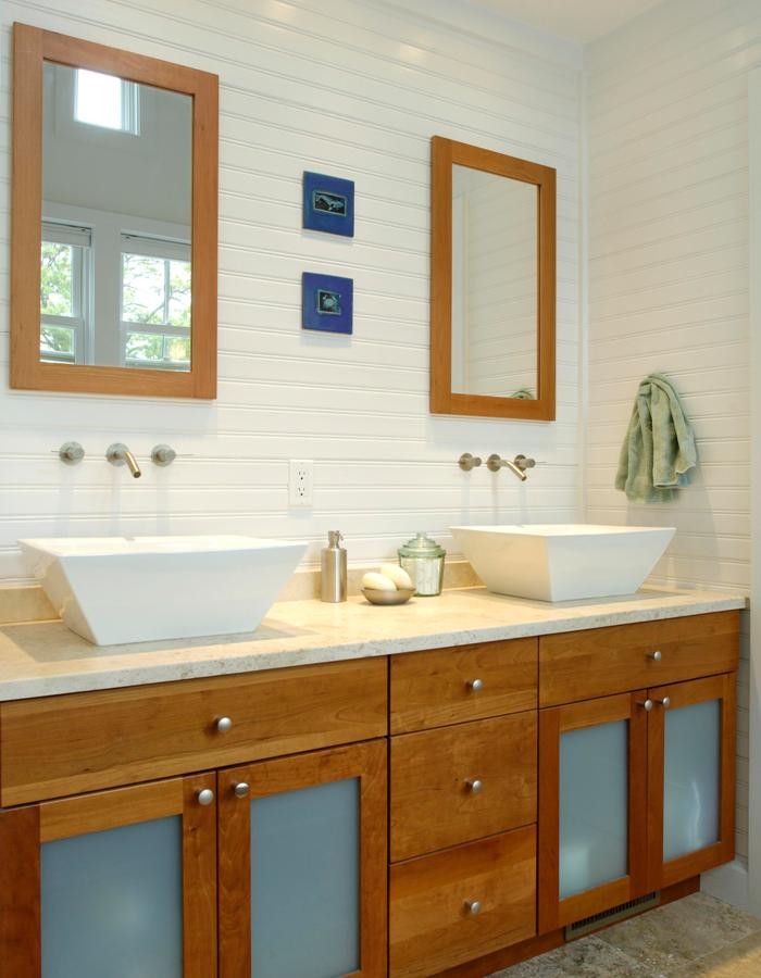 Inspiration for a mid-sized coastal master travertine floor and beige floor bathroom remodel in New York with shaker cabinets, medium tone wood cabinets, limestone countertops, a two-piece toilet, a vessel sink, white walls and a hinged shower door