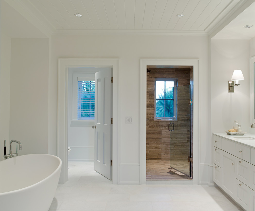 Esempio di una sauna minimal di medie dimensioni con ante in stile shaker, ante bianche, vasca freestanding, WC a due pezzi, pareti bianche, pavimento con piastrelle in ceramica, lavabo sottopiano e top in superficie solida