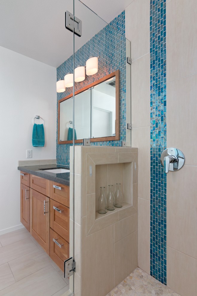 Источник вдохновения для домашнего уюта: главная ванная комната среднего размера в морском стиле с фасадами в стиле шейкер, фасадами цвета дерева среднего тона, накладной ванной, двойным душем, синей плиткой, стеклянной плиткой, белыми стенами, полом из керамической плитки, врезной раковиной, столешницей из гранита, бежевым полом, душем с распашными дверями и черной столешницей
