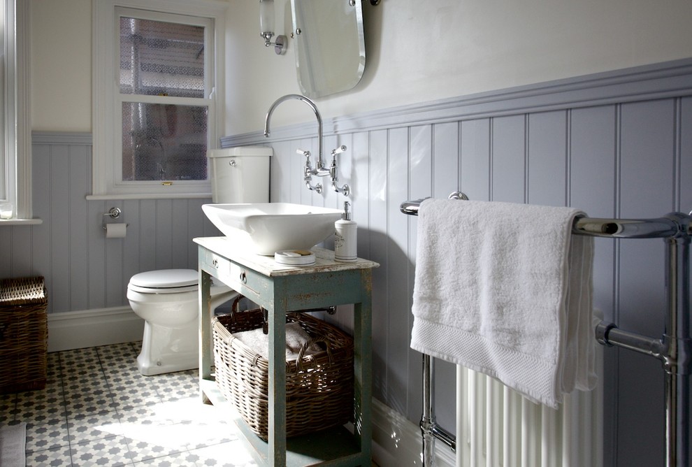 Inspiration for a medium sized traditional family bathroom in Sussex with distressed cabinets, a claw-foot bath, a shower/bath combination, a two-piece toilet, multi-coloured tiles, cement tiles, beige walls, mosaic tile flooring and a vessel sink.