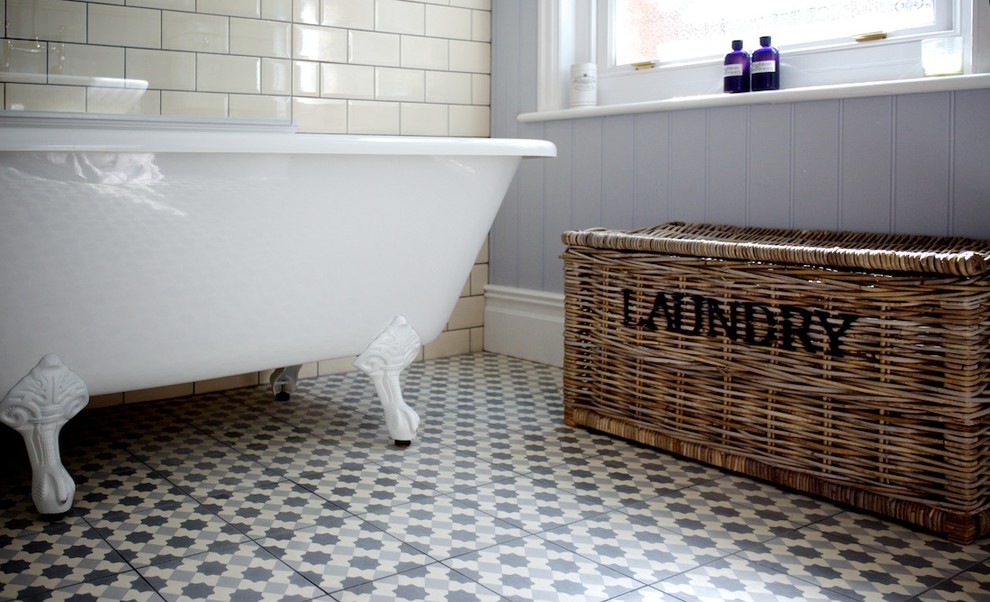 Inspiration for a medium sized shabby-chic style family bathroom in Sussex with a vessel sink, freestanding cabinets, distressed cabinets, wooden worktops, a claw-foot bath, a shower/bath combination, a two-piece toilet, beige tiles and cement tiles.