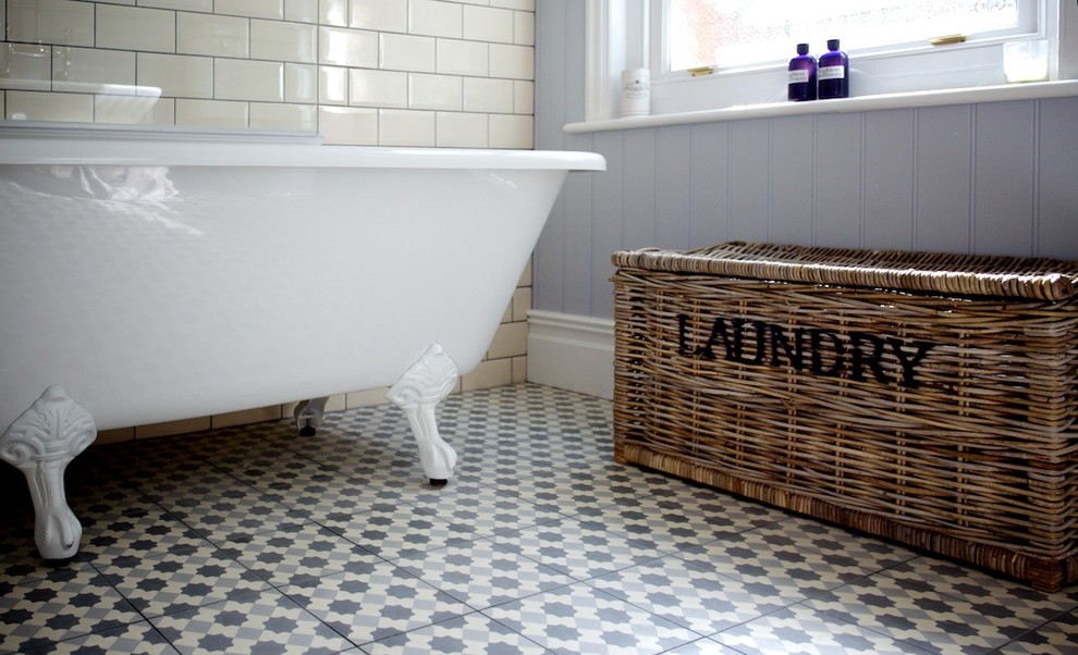 Immagine di una stanza da bagno per bambini stile shabby di medie dimensioni con lavabo a bacinella, consolle stile comò, ante con finitura invecchiata, top in legno, vasca con piedi a zampa di leone, vasca/doccia, WC a due pezzi, piastrelle beige e piastrelle di cemento