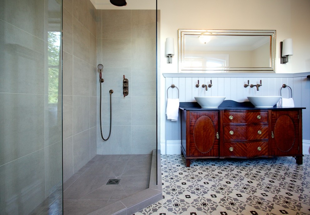 Cette image montre une grande salle de bain principale traditionnelle en bois brun avec une vasque, un placard en trompe-l'oeil, un plan de toilette en granite, une baignoire indépendante, une douche d'angle, WC séparés, un carrelage gris, des carreaux de porcelaine, un mur beige et un sol en carrelage de céramique.