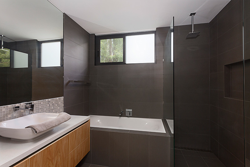 Inspiration för stora moderna vitt badrum, med ett avlångt handfat, möbel-liknande, skåp i ljust trä, ett platsbyggt badkar, en öppen dusch, grå kakel, keramikplattor, grå väggar och klinkergolv i keramik