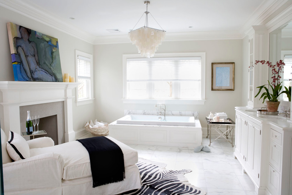 На фото: большая главная ванная комната в классическом стиле с фасадами с утопленной филенкой, белыми фасадами, мраморным полом, мраморной столешницей, накладной ванной и бежевыми стенами