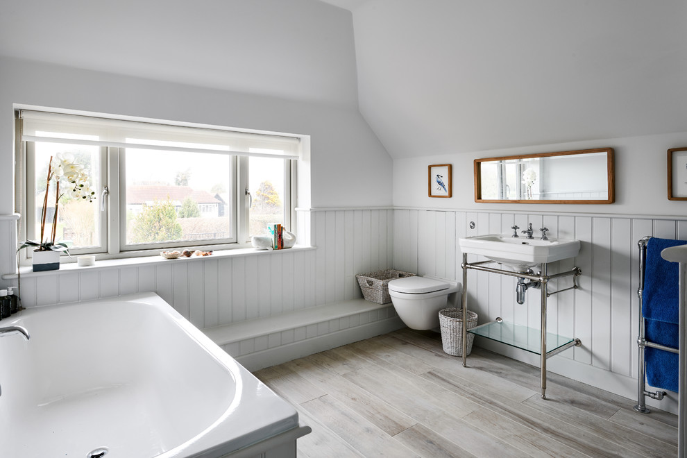Ejemplo de cuarto de baño infantil costero pequeño con bañera encastrada, paredes grises, sanitario de pared, lavabo tipo consola y suelo beige